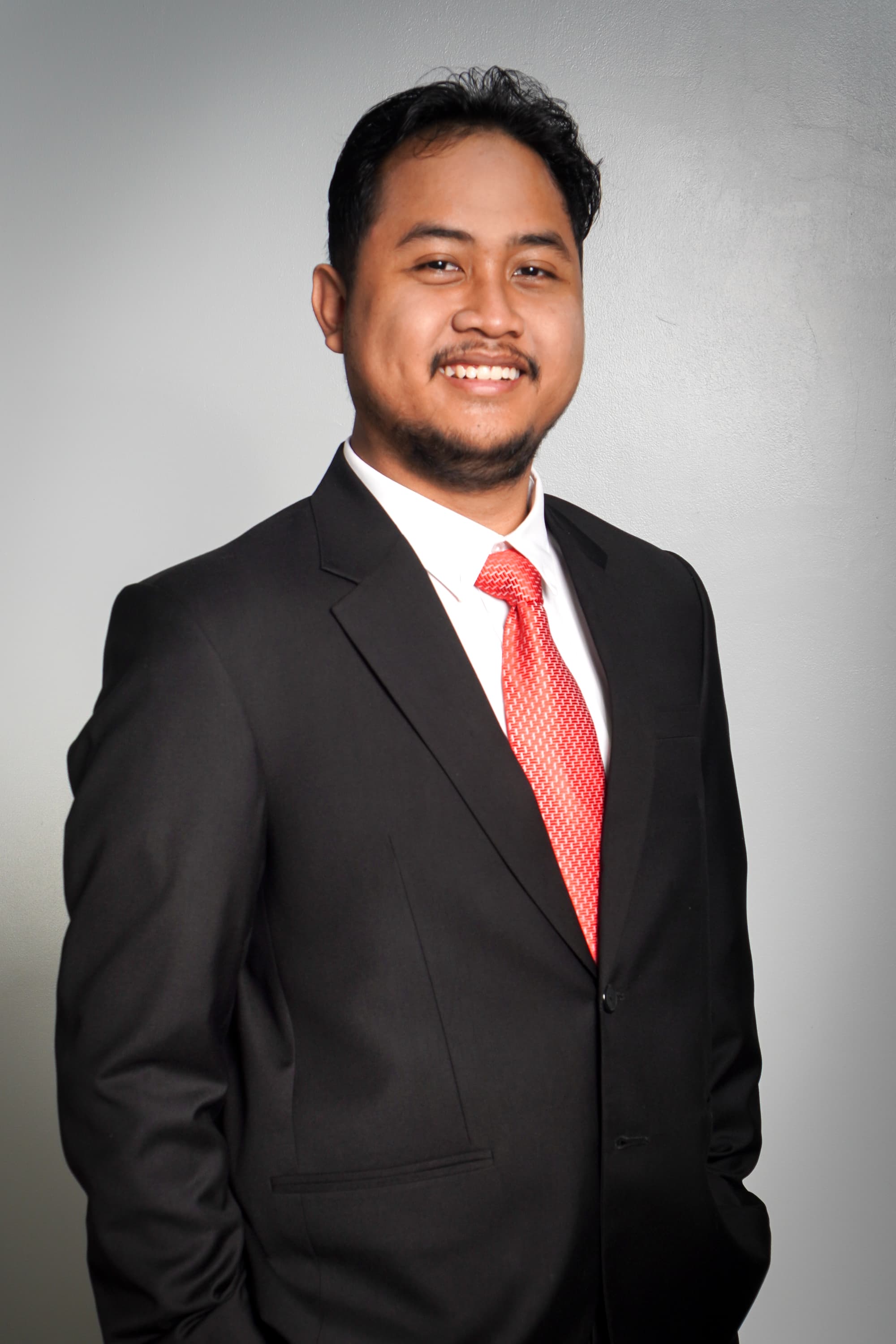 Portrait of Dawwi in a black suit